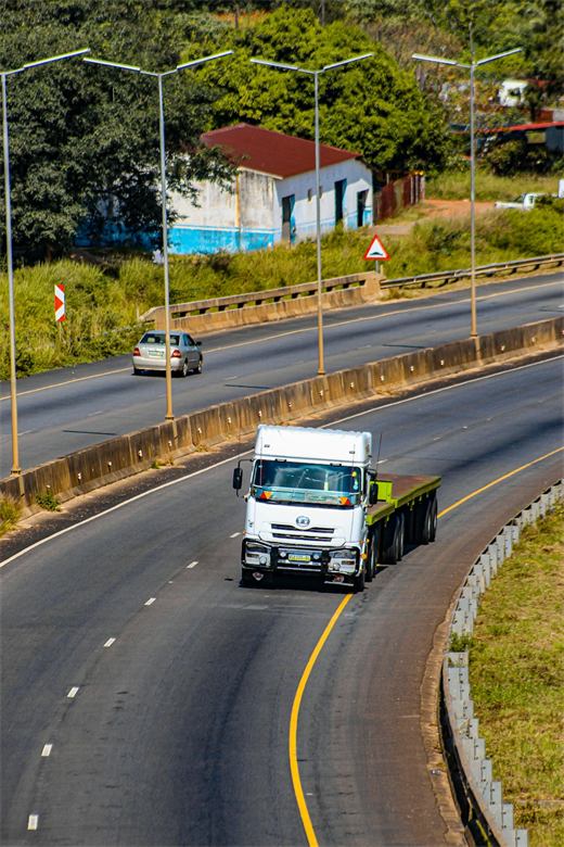 Caminhão de carga seguindo viagem por uma rodovia